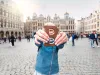Woman with milk chocolate bar standing on the Grand place in Brussels in Belgium.