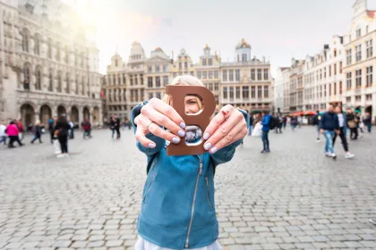 Woman with milk chocolate bar standing on the Grand place in Brussels in Belgium.
