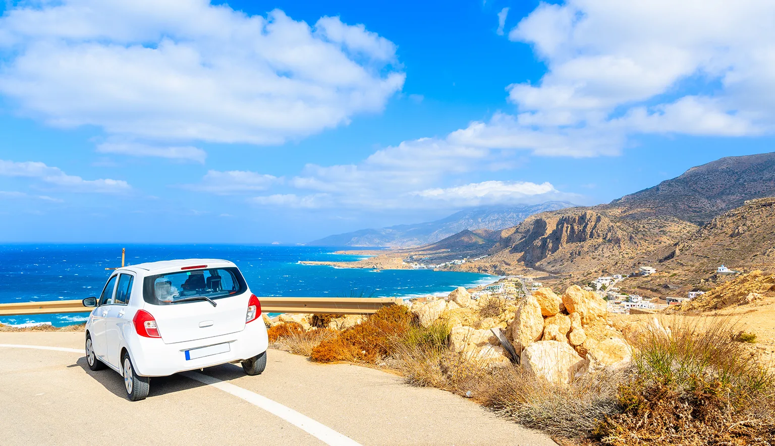 Rental car parked on road side during coastal drive, Crete, Greece