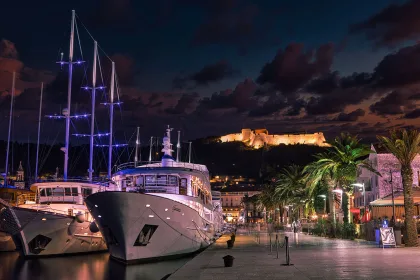 Hvar at night with boats and castle in background
