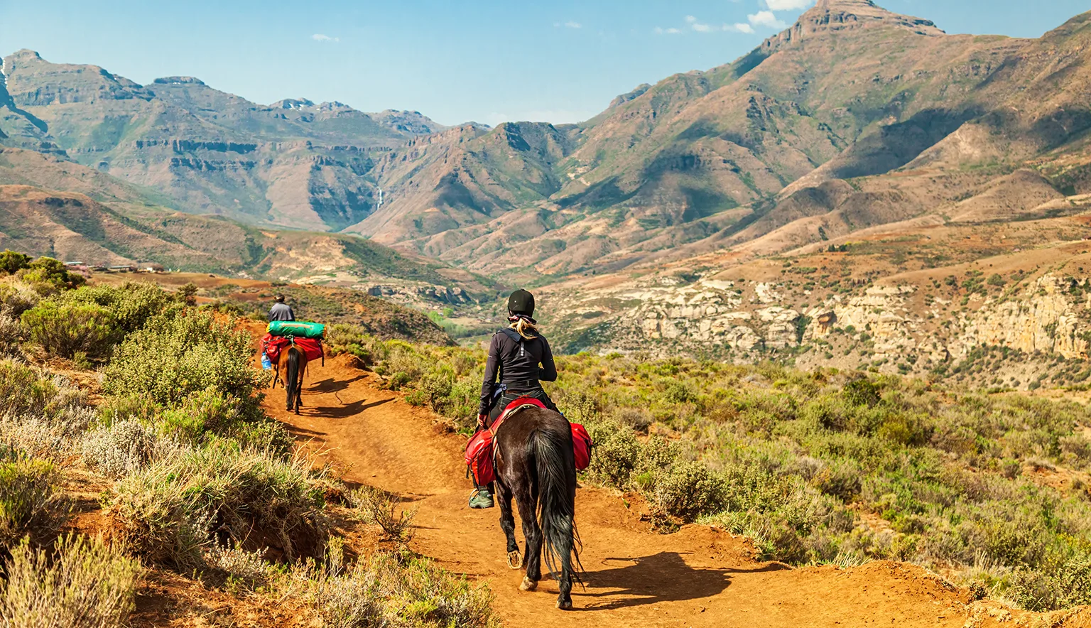 Female tourist riding on a Basotho Poney in Lesotho