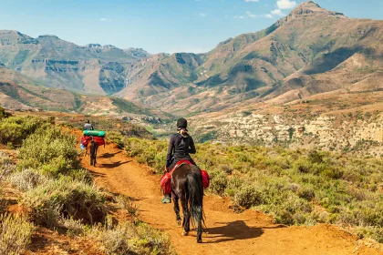 Female tourist riding on a Basotho Poney in Lesotho