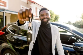 Portrait of man car seller holding car keys.