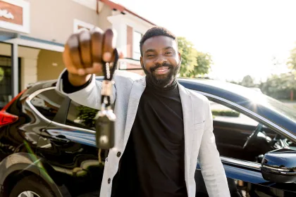 Portrait of man car seller holding car keys.