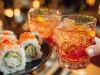Close up of sushi rolls with salmon on plate with cocktail glass