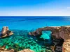 Woman on the beautiful natural rock arch near of Ayia Napa, Cavo Greco and Protaras