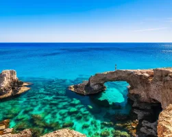 Woman on the beautiful natural rock arch near of Ayia Napa, Cavo Greco and Protaras