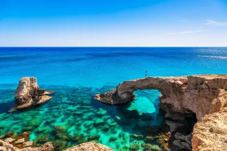 Woman on the beautiful natural rock arch near of Ayia Napa, Cavo Greco and Protaras