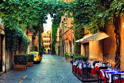 Beautiful ancient street in Rome lined with leafy vines and cafe
