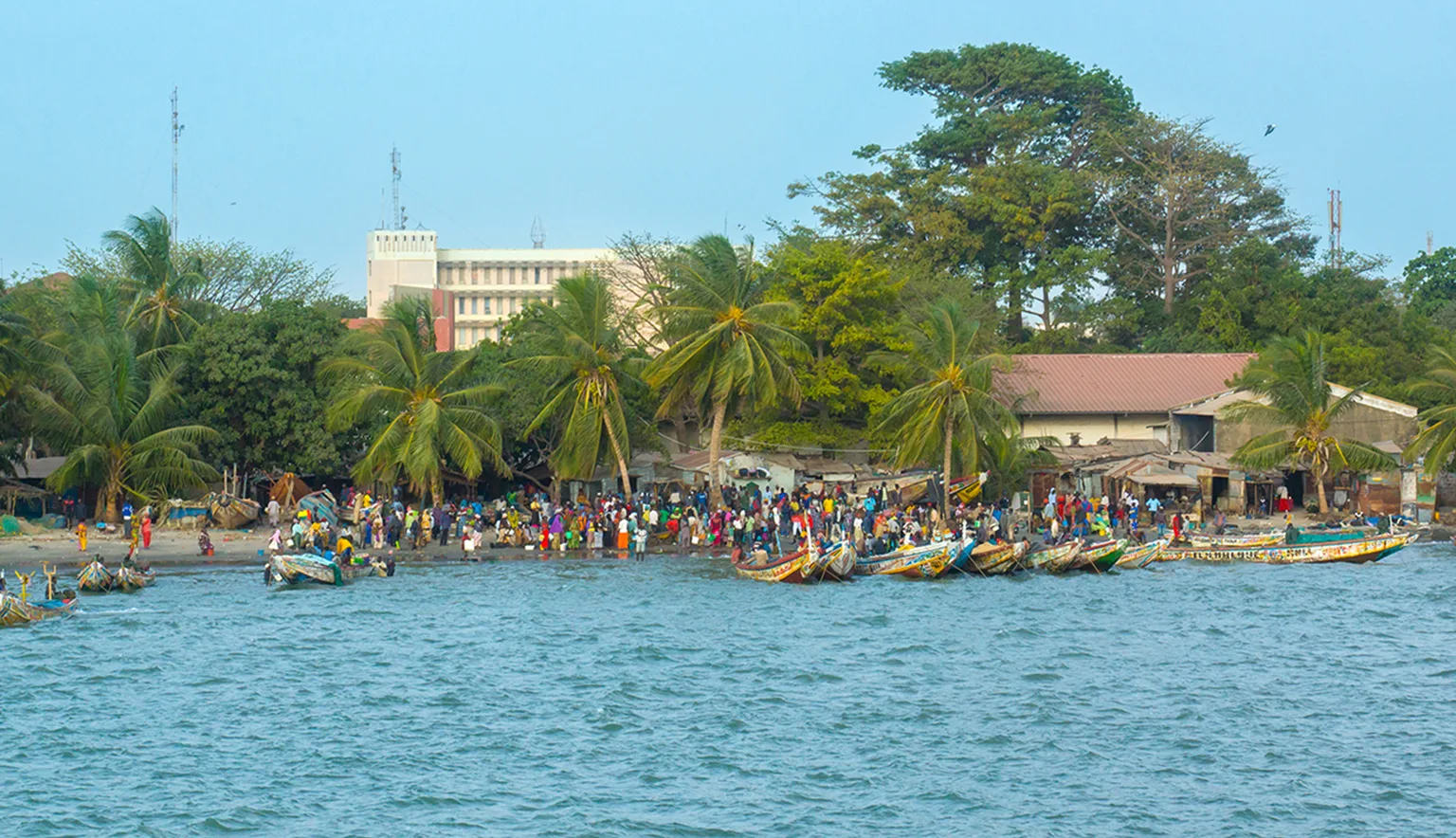 African people and boats on the shoreline of Banjul in Gambia, West Africa