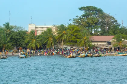 African people and boats on the shoreline of Banjul in Gambia, West Africa